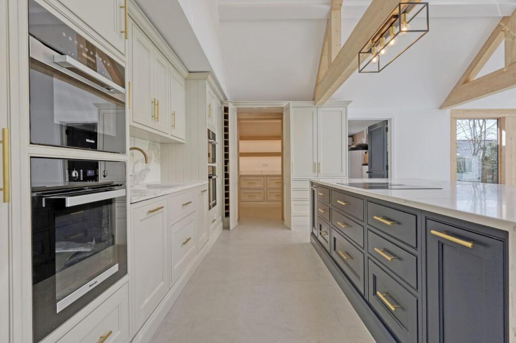 Bespoke kitchen cabinetry leading into a hidden pantry